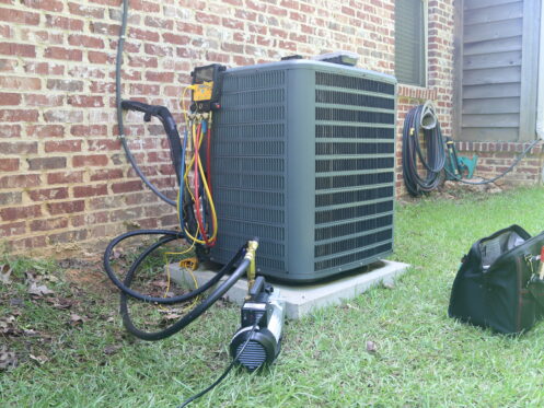 An AC unit in the backyard of a Middletown home getting maintenance.