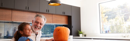 Family carving pumpkin in kitchen